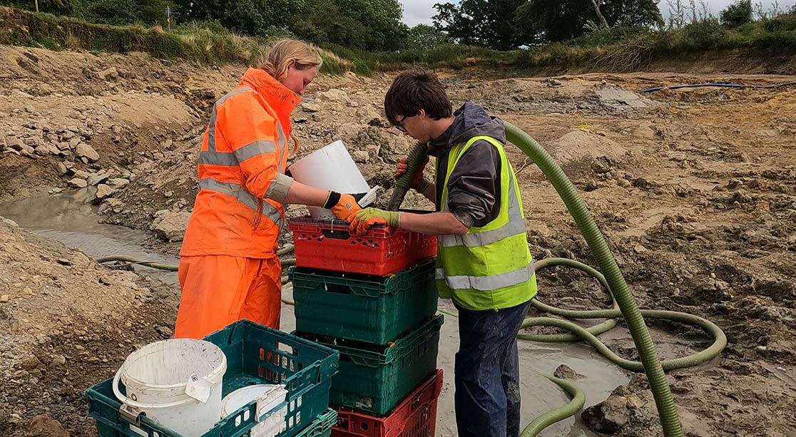 University of Winchester Archaeology staff and student processing soil samples by wet sieving them